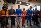 Marta Malec-Lech z zarządu województwa oraz postali uczestnicy uroczystości przecinają wstęgę.