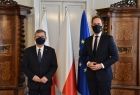 marszałek Witold Kozłowski i Jakub Kwaśny - przewodniczący rady miejskiej w Tarnowie stoją na tle flag w gabinecie