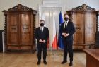 marszałek Witold Kozłowski i Jakub Kwaśny - przewodniczący rady miejskiej w Tarnowie stoją na tle flag w gabinecie
