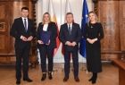 Marszałek Witold Kozłowski i wicemarszałek Łukasz Smółka stoją w gabinecie z nowym dyrektorem. Z tyłu widoczne zabytkowe meble i flagi Małopolski, Polski i Unii Europejskiej.