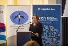 Kobieta stojąca za pulpitem podczas konferencji naukowej.