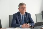 Marszałek Witold kozłowski siedzi przy stole i komputerze.