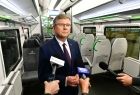 Marszałek Witold Kozłowski udziela wywiadu przedstawicielom mediów w środku pociągu Elf2. Na pierwszym planie widoczne mikrofony.