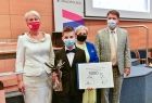 Wspólne pamiątkowe zdjęcie, grupa osób wraz z laureatem