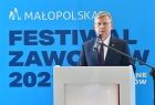 Marszałek Witold Kozłowski na tle banneru Festiwalu Zawodów