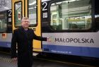Marszałek Witold Kozłowski stoi przy pociągu.