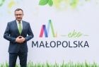 Wicemarszałek Tomasz Urynowicz na tle banneru EkoMałopolska