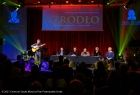 gala Małopolskiej Nagrody Poetyckiej, na scenie jury, przy mikrofonie z gitarą stoi mężczyzna