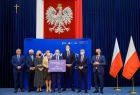 Grupa gości wydarzenia stoi na podwyższeniu razem z przedstawicielem gminy Dębno, wśród nich wicemarszałek Józef Gawron