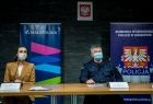 Marta Malec-Lech z zarządu województwa siedzi podczas konferencji. Obok policjant w mundurze.