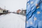 Droga pod śniegiem, z boku z prawej strony widoczna flaga Unii Europejskiej