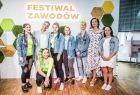 Uczestnicy wydarzenia z prowadzącą studio i Martą Malec-Lech na ściance z napisem "Festiwal Zawodów"