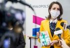 Marta Malec-Lech z Zarządu Województwa Małopolskiego prezentuje podczas konferencji prasowej kartki edukacyjne przygotowane w ramach akcji „Wnuczka, wnuczek edukuje - babcia, dziadek się stosuje!”