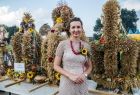 Marta Malec-Lech z zarządu województwa na tle wieńców dożynkowych.