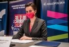 Marta Malec-Lech z zarządu województwa siedzi przy stole podczas konferencji.