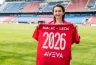 Marta Malec-Lech z zarządu województwa stoi na płycie boiska i trzyma czerwoną koszulkę.