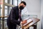 Wicemarszałek Łukasz Smółka wpisuje się do pamiątkowej księgi