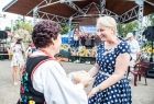 Iwona Gibas z kobietą w stroju regionalnym na tle sceny