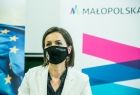 Marta Malec-Lech z Zarządu Województwa Małopolskiego na tle baneru z napisem i logiem Małopolski