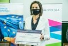 Marta Malec-Lech z zarządu województwa prezentuje okazałe promesy na zakup sprzętu komputerowego