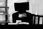 Zdjęcie czarno-białe autorstwa Andrzeja Błońskiego, przedstawiające żyda chasydzkiego w futrzanej czapie czytającego książkę.