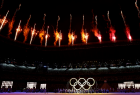 Ceremonia otwarcia Igrzysk Olimpijskich w Tokio. Widoczne ognie i koła olimpijskie.