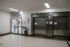 Korytarz szpitala w Dąbrowie Tarnowskiej. Widać wejście na oddział chirurgii urazowo-ortopedycznej i nowoczesne windy.
