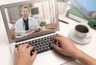Teleporada lekarska, na ekranie laptopa lekarz. Obok stoi filiżanka z kawą.