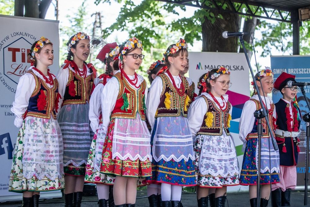 Uczestniczki konkursu piosenki w strojach ludowych na scenie 