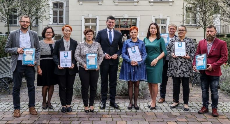 Wicemarszałek Łukasz Smółka stoi na dziedzicu urzędu z nowymi członkami Sieci Dziedzictwa Kulinarnego Małopolska.