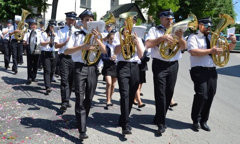 Orkiestra Dęta OSP w Głogoczowie maszeruje po ulicy i gra.