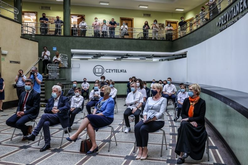 Iwona Gibas siedzi na sali wśród innych osób
