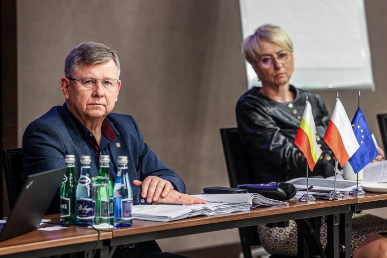 marszałek Witold Kozłowski siedzi przy stole, w tle Iwona Gibas członek zarządu