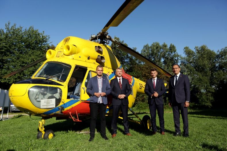 Łukasz Pieniążek prezes OSP „Muzeum Ratownictwa” w Krakowie, Dawid Gleń rzecznik UMWM, Grzegorz Twardy przewodniczący Rady Gminy oraz Ziyad Raoof właściciel Dworu w Tomaszowicach. W tle widoczny śmigłowiec.