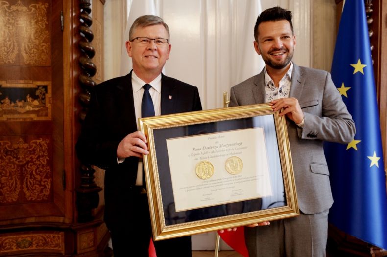 Wręczenie polonii minor. Na zdjęciu marszałek i Dariusz Martynowicz. w tle flagi