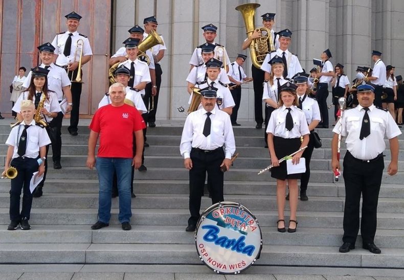 Orkiestra Dęta Barka pozuje na schodach.