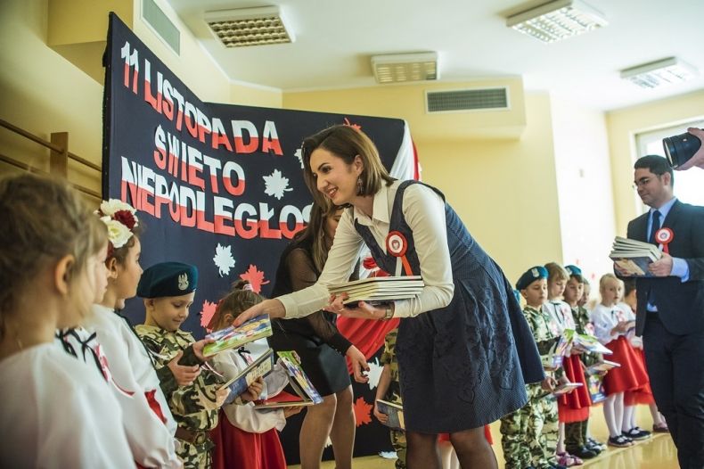 Marta Malec-Lech z zarządu województwa rozdaje książeczki dzieciom.