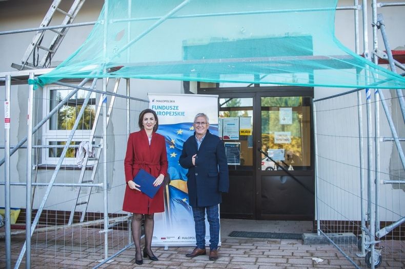 Marta Malec_Lech zarządu województwa stoi przed budynkiem modernizowanej szkoły.