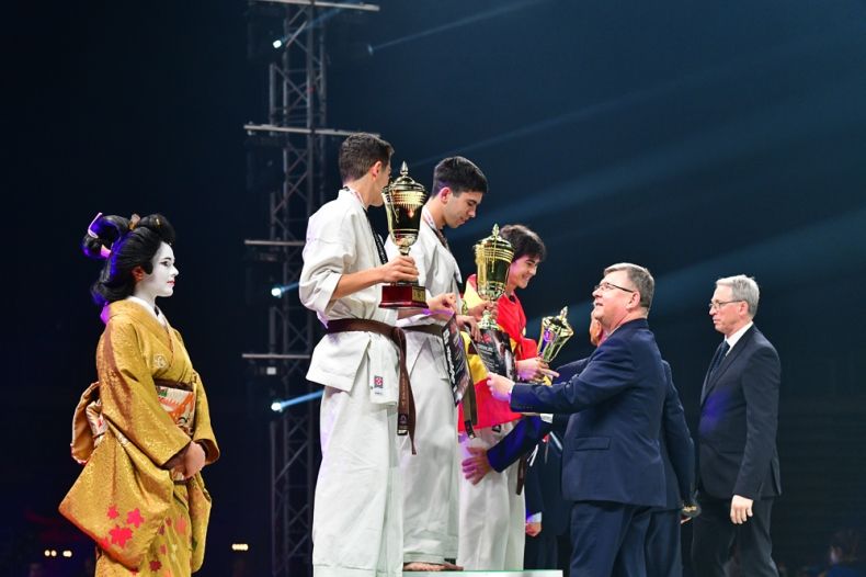 dekoracja zwycięzców, zawodnicy na podium trzymają puchary