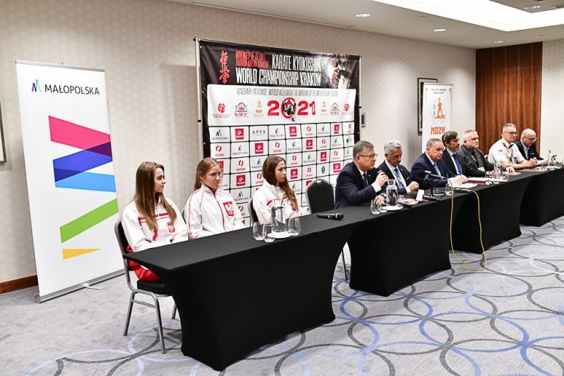 kilka osób siedzi przy stole podczas konferencji prasowej dotyczącej Mistrzostw Świata w Karate