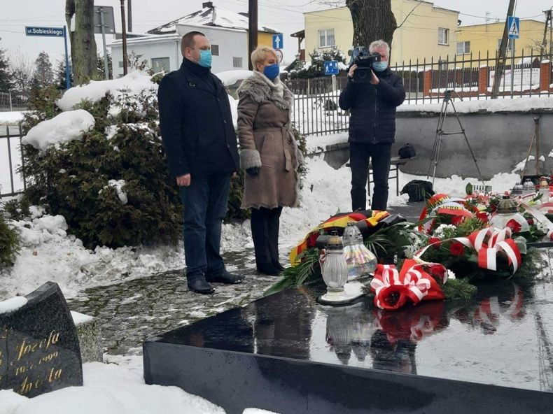 Iwona Gibas z zarządu województwa i Jakub Powroźnik z agendy UMWM stoją przed pomnikiem