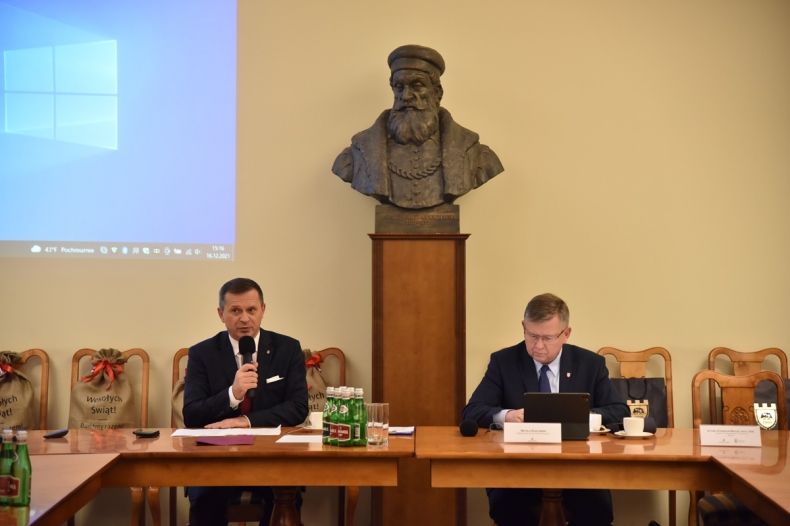 rektor Stanisław Mazur i marszałek Witold Kozłowski siedzą przy stole, w tle rzeźba - popiersie