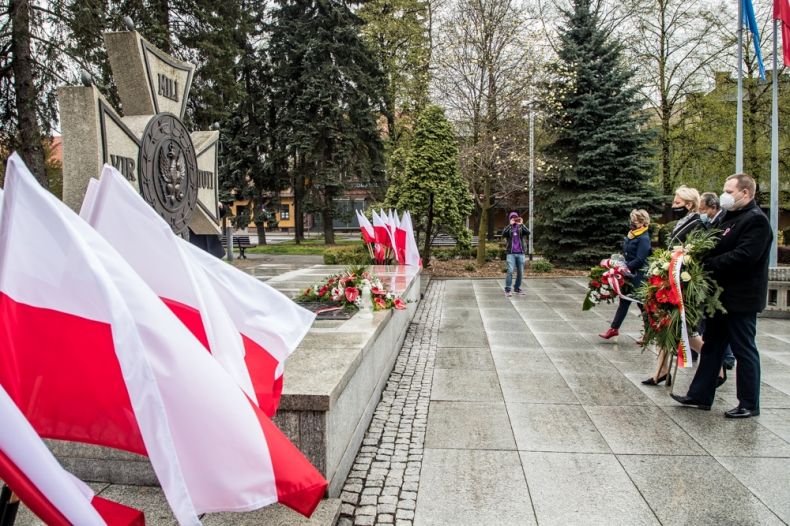 Iwona Gibas z Zarządu Województwa Małopolskiego składa kwiaty podczas obchodów Święta Narodowego Trzeciego Maja w Oświęcimiu. Iwonie Gibas z ZWM towarzyszy Jakub Przewoźnik, kierownik agendy UMWM w Oświęcimiu