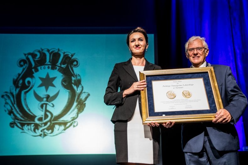 Marta Malec-Lech z zarządu województwa przekazuje nagrodę.