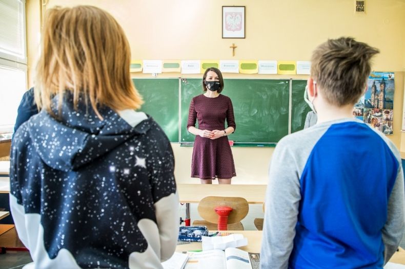 Marta Malec-Lech z zarządu województwa stoi w klasie szkolnej. Na zdjęciu znajdują się także dzieci. W tle widoczna tablica.