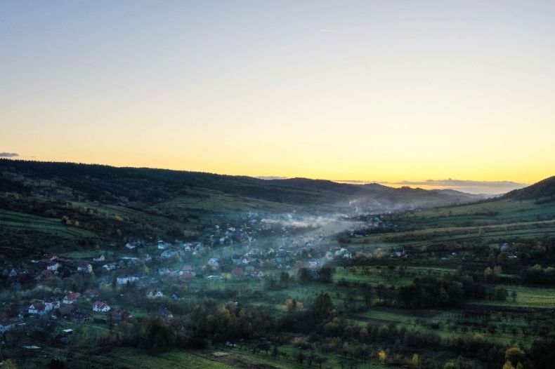 Dym unosi się z kominów nad zabudową jednorodzinną