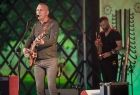 czas koncertu na scenie. Na pierwszym planie wokalista zespołu Raz Dwa Trzy z gitarą śpiewający