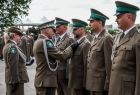Generał przypina odznaczenia funkcjonariuszom straży granicznej.