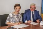 Marta Malec-Lech z zarządu województwa podpisuje umowę, obok siedzi wicemarszałek Józef Gawron.