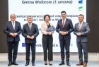 Marszałek Witold Kozłowski i wicemarszałkowie Łukasz Smółka i Józef Gawron stoją na scenie z przedstawicielką Gminy Wolbrom.
